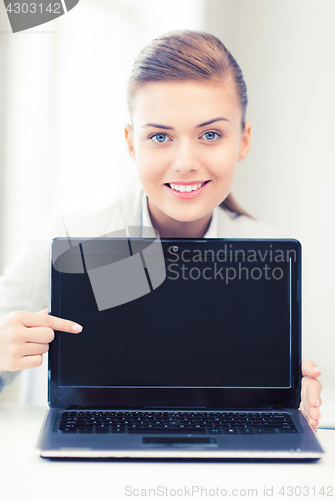 Image of businesswoman with laptop in office