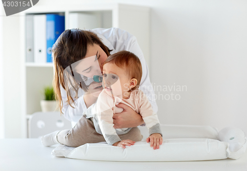 Image of doctor with otoscope checking baby ear at clinic