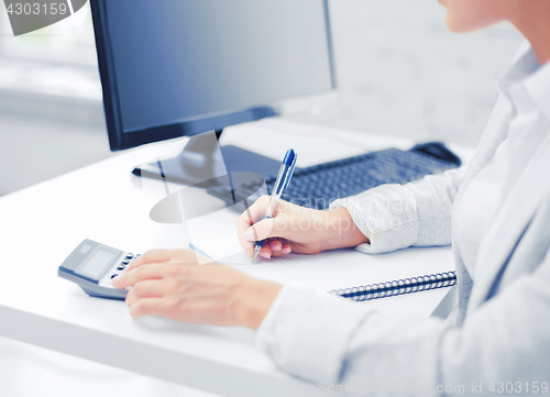 Image of businesswoman with notebook and calculator