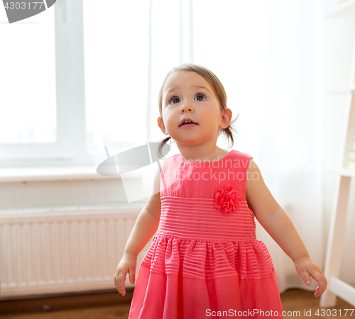 Image of happy baby girl in dress at home