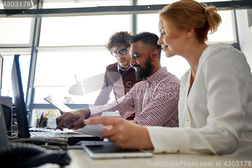 Image of business team with laptop and coffee in office