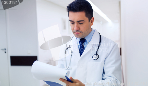 Image of doctor writing to clipboard at hospital