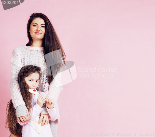 Image of young mother with little cute daughter emotional posing on pink background, happy smiling family inside isolated adorable, lifestyle people concept 