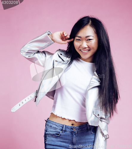 Image of young pretty smiling asian korean girl wearing modern fashion clothers on pink background, lifestyle people concept 