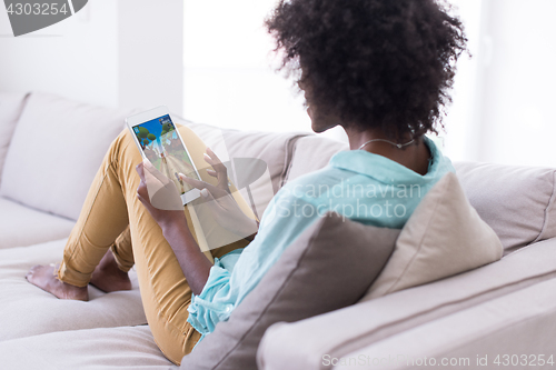 Image of african american woman at home using digital tablet