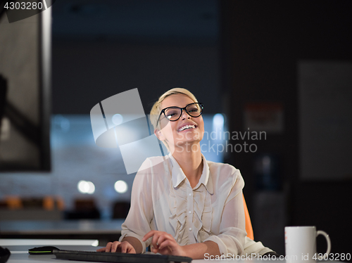 Image of woman working on computer in dark office