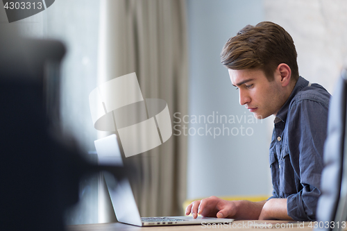 Image of businessman working using a laptop in startup office