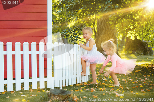 Image of The two little girls at playground against park or green forest