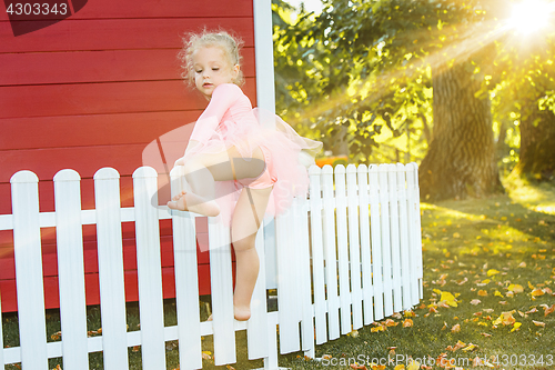 Image of The little girl at playground against park or green forest