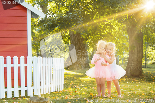 Image of The two little girls at playground against park or green forest