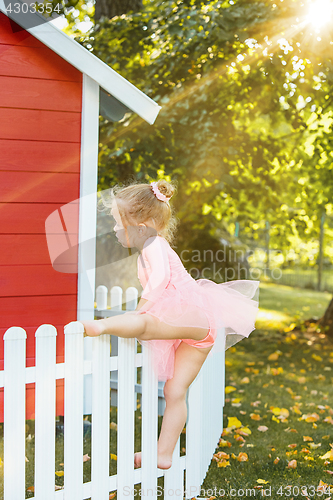 Image of The little girl at playground against park or green forest