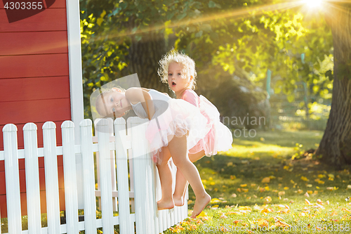 Image of The two little girls at playground against park or green forest