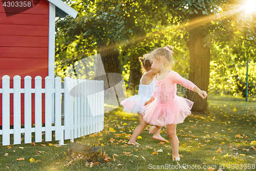 Image of The two little girls at playground against park or green forest