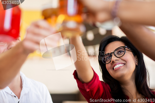 Image of friends clinking glasses with drinks at restaurant