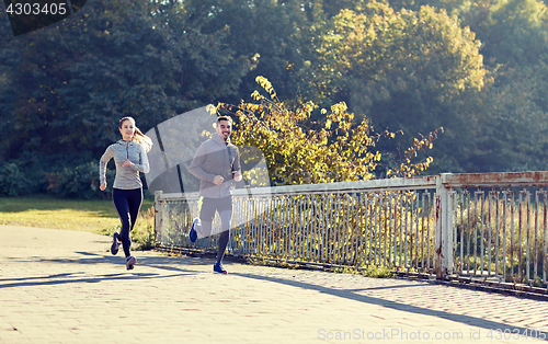 Image of happy couple running outdoors