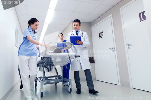 Image of medics with woman on hospital gurney at emergency