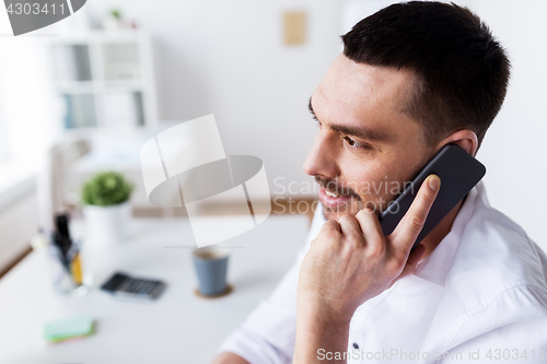 Image of businessman calling on smartphone at office