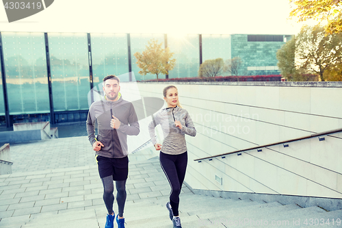 Image of happy couple running upstairs on city stairs