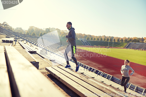 Image of happy couple running upstairs on stadium