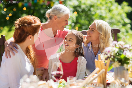 Image of happy family having dinner or summer garden party