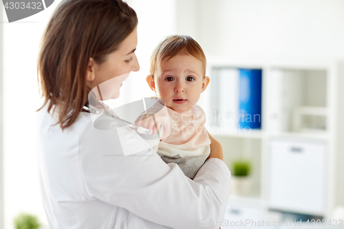 Image of happy doctor or pediatrician with baby at clinic