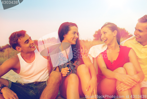 Image of smiling friends in sunglasses on summer beach