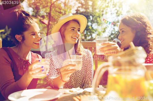 Image of happy friends having party at summer garden