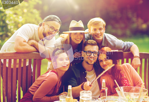 Image of friends taking selfie at party in summer garden