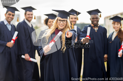 Image of happy student with diploma pointing finger at you