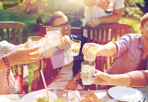 Image of happy friends with drinks at summer garden party