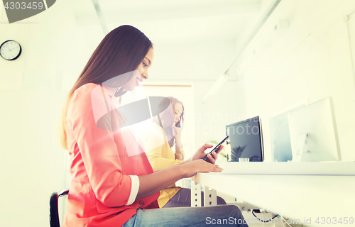 Image of businesswoman texting on smartphone at office