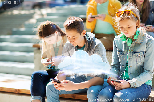 Image of teenage friends with smartphones outdoors