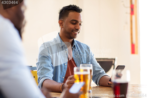 Image of happy male friends drinking beer at bar or pub