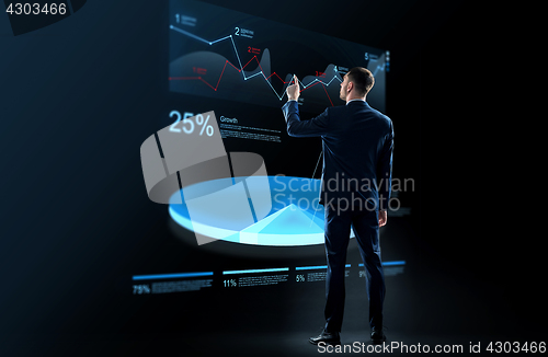 Image of businessman working with virtual chart hologram