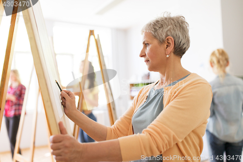 Image of woman artist with pencil drawing at art school