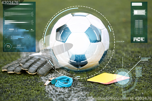 Image of ball, gloves, whistle and cards on soccer field