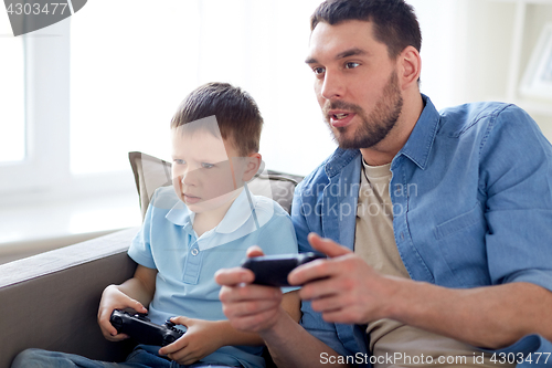 Image of father and son playing video game at home