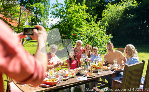 Image of happy family photographing by smartphone in summer