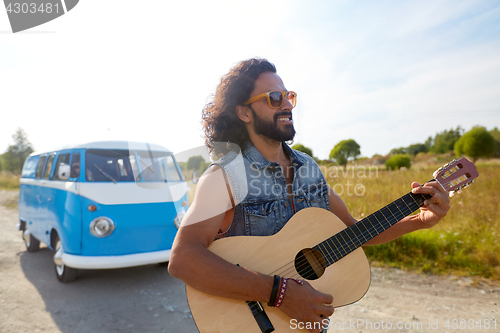 Image of hippie man playing guitar at minivan car outdoor