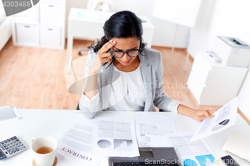 Image of businesswoman with laptop working at office