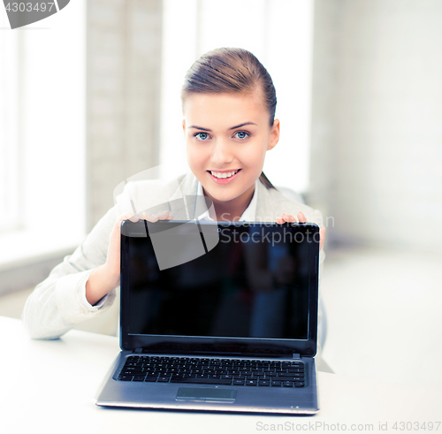 Image of businesswoman with laptop in office