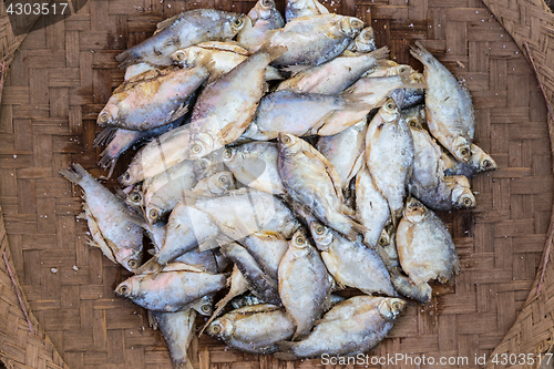 Image of Mackerel fishes in round bamboo basket for sale in local market.