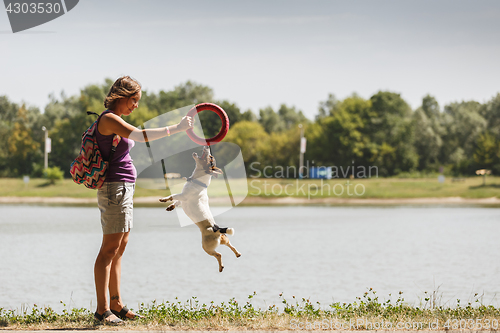 Image of Woman playing with dog on nature