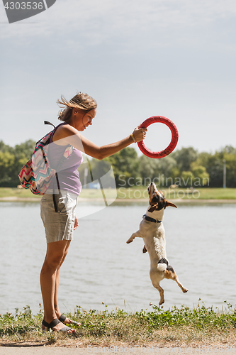 Image of Woman playing with dog on nature