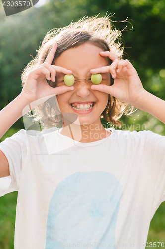 Image of Cheerful girl playing with plums