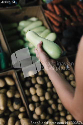 Image of Crop person buying vegetables