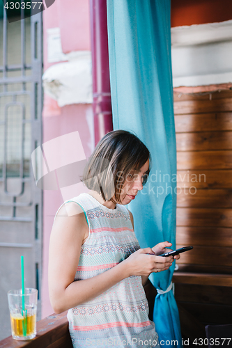 Image of Girl using smartphone in cafe