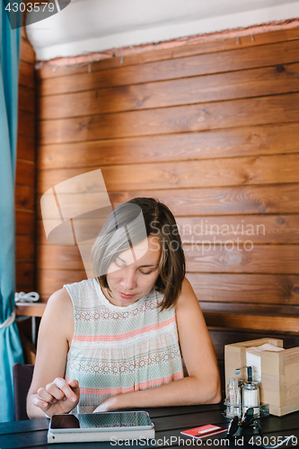 Image of Girl in cafe with drink and tablet