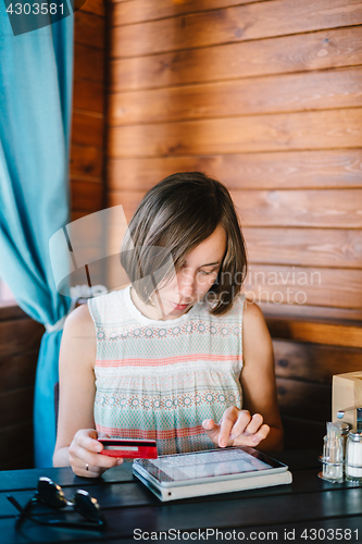 Image of Girl in cafe with drink and tablet