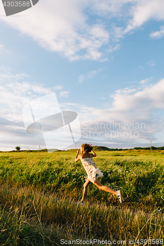 Image of Cheerful girl running with kite